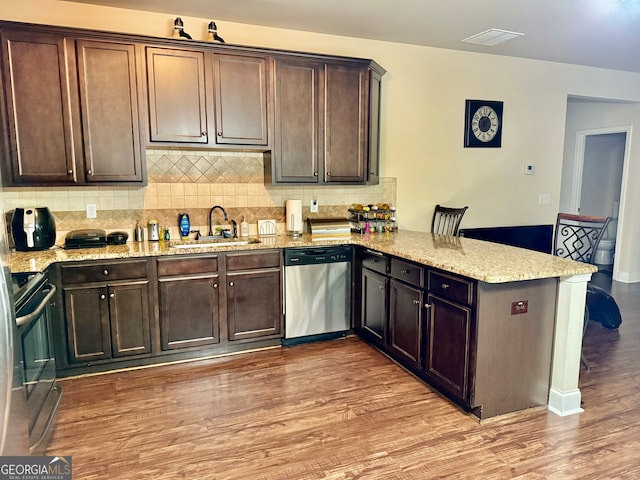 kitchen featuring kitchen peninsula, sink, stainless steel dishwasher, electric range, and light wood-type flooring