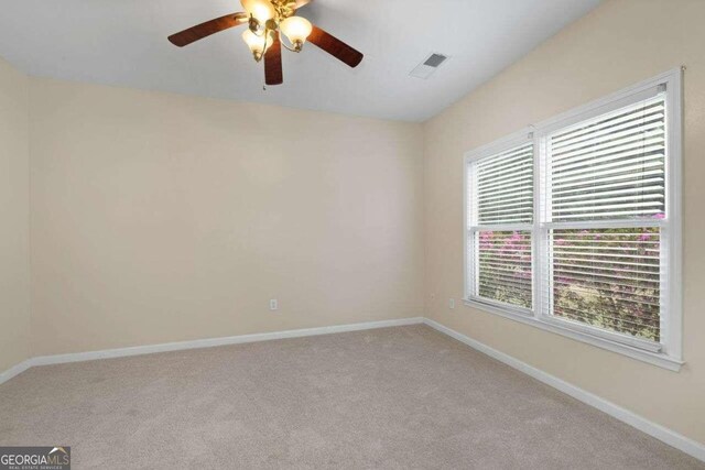 spare room with light colored carpet and ceiling fan