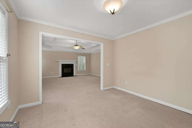 unfurnished living room with ceiling fan, light colored carpet, a raised ceiling, and crown molding