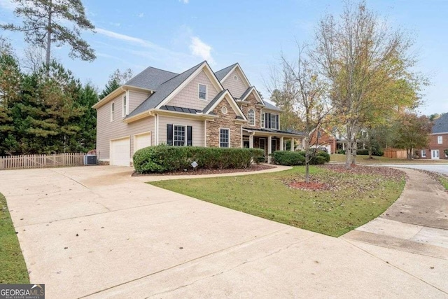 view of front of home featuring a garage, central AC, and a front yard