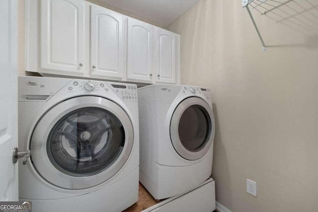 laundry area with cabinets and washing machine and dryer