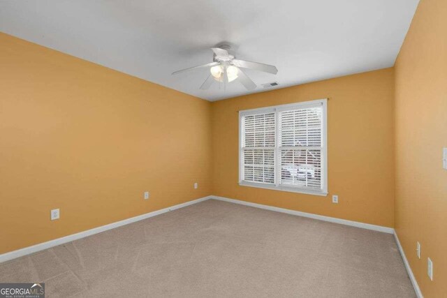 carpeted empty room featuring ceiling fan