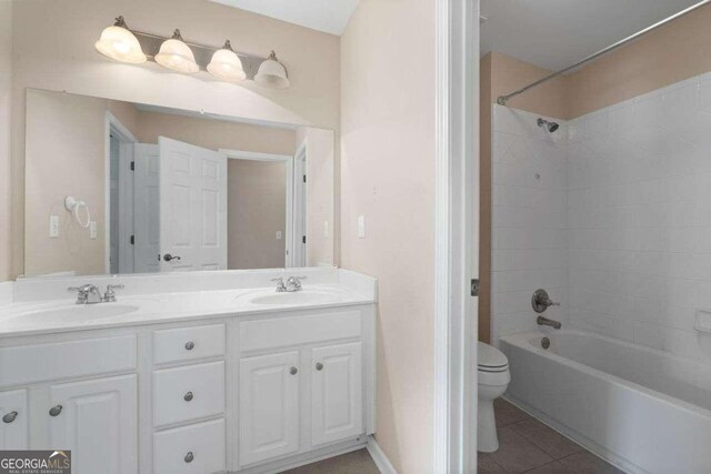 full bathroom with toilet, vanity, tiled shower / bath, and tile patterned flooring