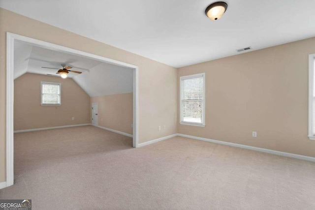 additional living space featuring plenty of natural light, ceiling fan, light colored carpet, and vaulted ceiling