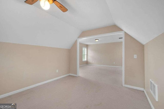 bonus room with lofted ceiling, light carpet, and ceiling fan