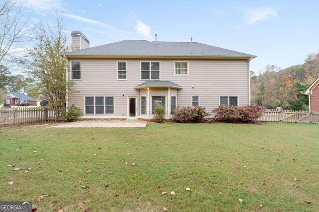 back of house with a lawn