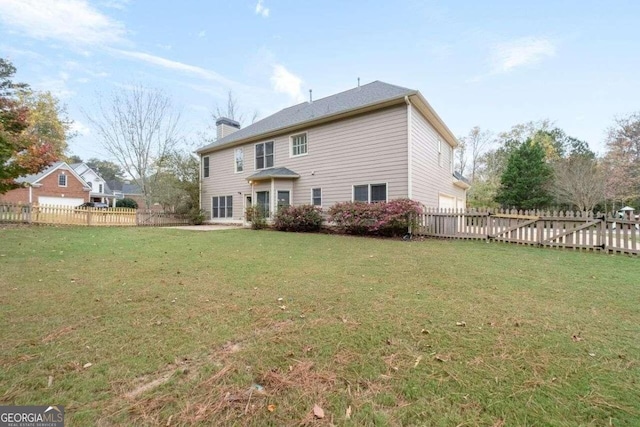 rear view of property featuring a lawn