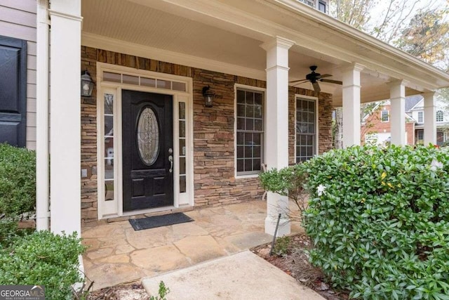 view of exterior entry featuring ceiling fan and a porch