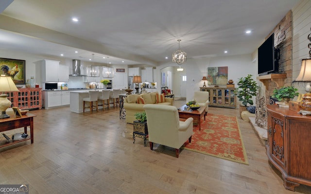 living room featuring light wood-type flooring and a notable chandelier