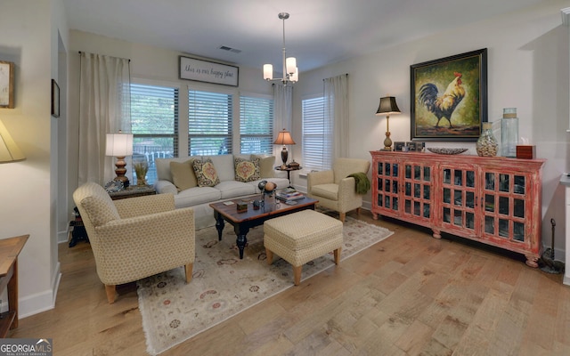 living room with light wood-type flooring and a chandelier