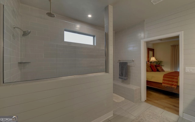 bathroom featuring tile patterned flooring and tiled shower