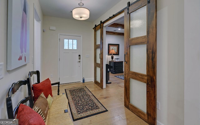 foyer featuring a barn door and light hardwood / wood-style floors