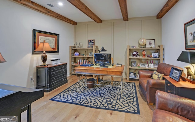 office with light hardwood / wood-style floors and beamed ceiling