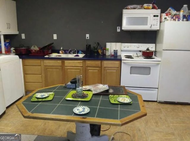 kitchen featuring light tile patterned floors, light brown cabinets, sink, tile counters, and white appliances