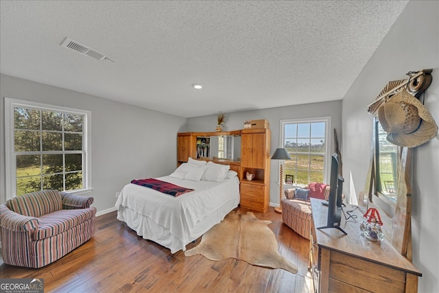 bedroom with wood-type flooring and a textured ceiling