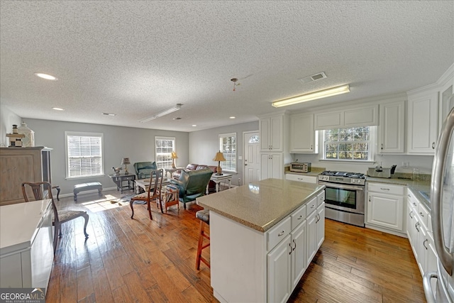 kitchen with white cabinetry, a center island, a wealth of natural light, and stainless steel appliances