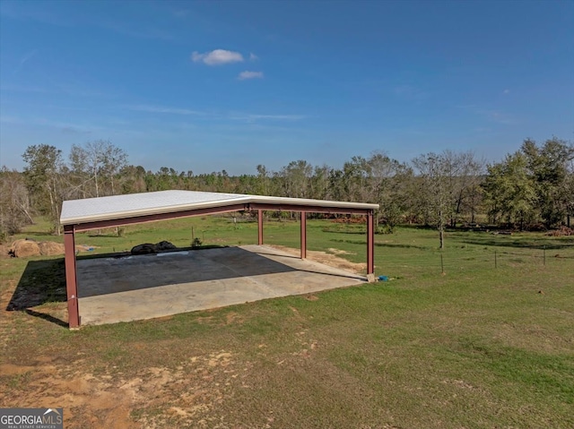 view of car parking featuring a yard, a rural view, and basketball hoop