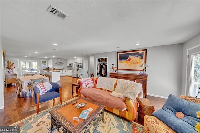 living room with light hardwood / wood-style flooring and a textured ceiling