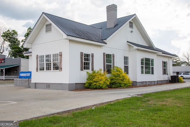 view of side of home featuring central AC and a yard