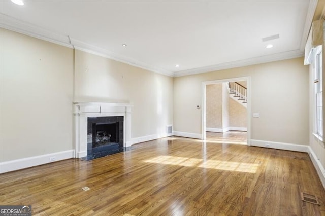 unfurnished living room featuring wood-type flooring and crown molding