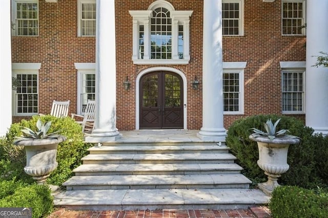 view of exterior entry with a porch and french doors