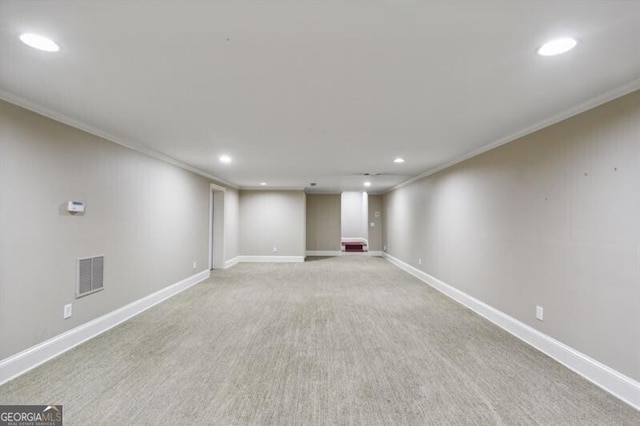 basement with light colored carpet and ornamental molding