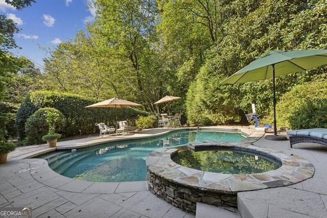 view of swimming pool featuring an in ground hot tub and a patio