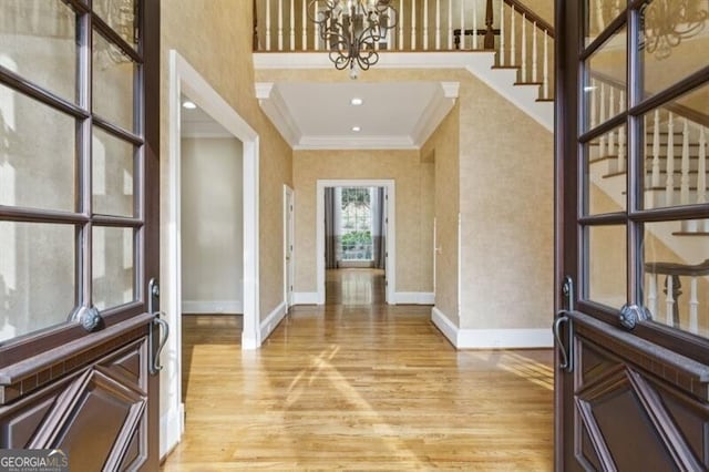 entrance foyer featuring a notable chandelier, light hardwood / wood-style floors, and ornamental molding