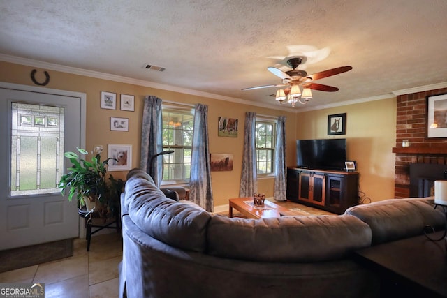 living room featuring visible vents, crown molding, a textured ceiling, and light tile patterned floors