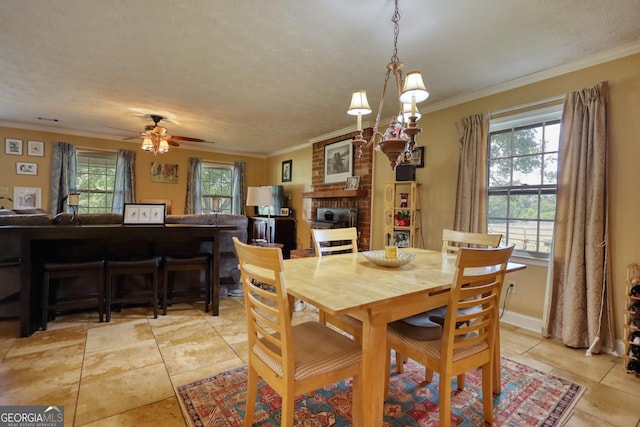 dining space featuring ornamental molding, a brick fireplace, a textured ceiling, and a ceiling fan