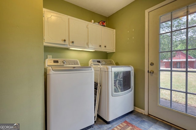 laundry area with cabinet space, plenty of natural light, separate washer and dryer, and dark tile patterned flooring