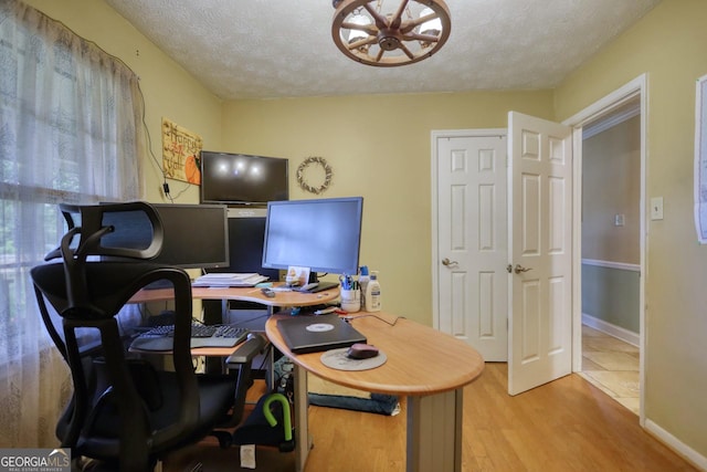 office space featuring a textured ceiling and light hardwood / wood-style flooring