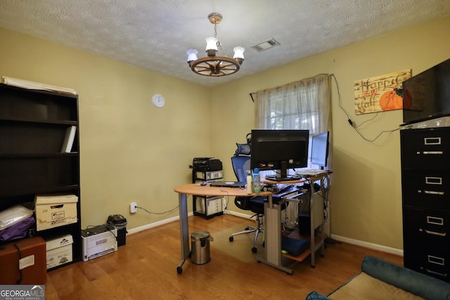 office area featuring a chandelier, hardwood / wood-style floors, and a textured ceiling