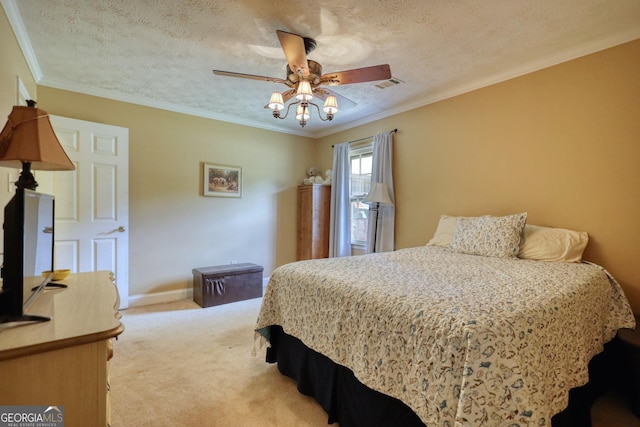 bedroom with a textured ceiling, light colored carpet, ceiling fan, and ornamental molding