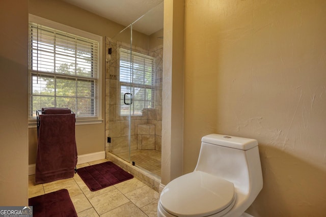 bathroom featuring tile patterned floors, a shower with shower door, and toilet