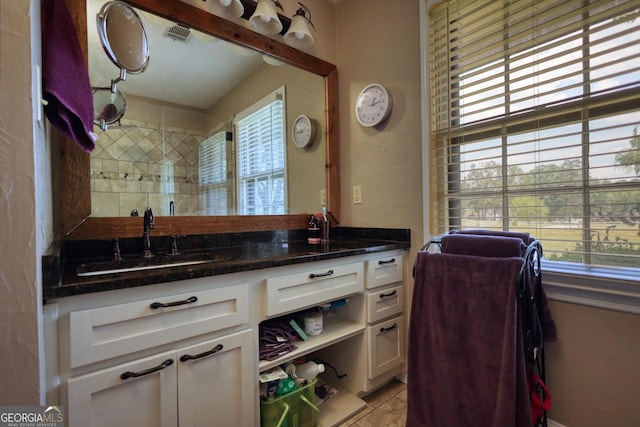 bathroom with visible vents, a healthy amount of sunlight, and vanity