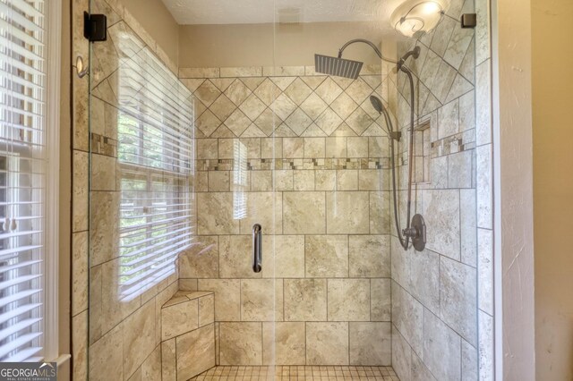 bathroom with a shower with door and a textured ceiling