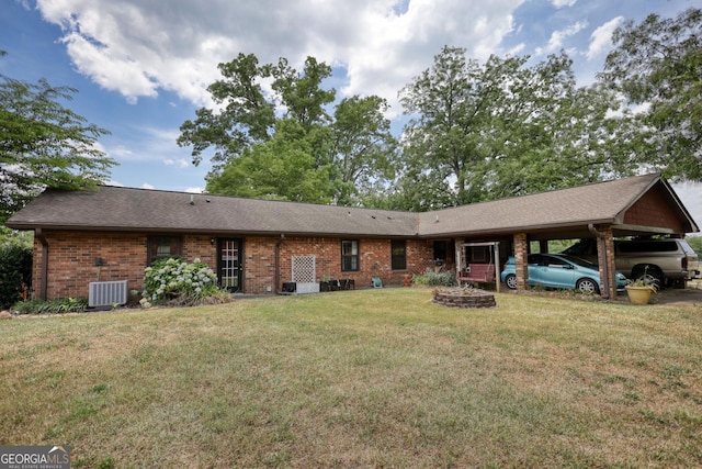 ranch-style home featuring central AC, brick siding, and a front lawn