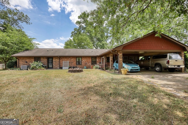 view of front of house featuring driveway, a front lawn, cooling unit, and brick siding