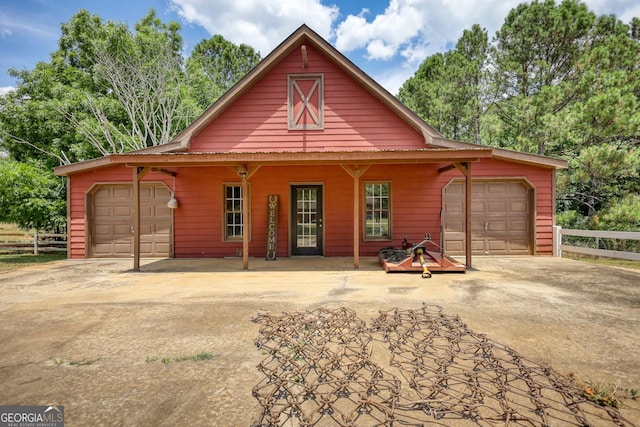 chalet / cabin with a garage, driveway, and fence