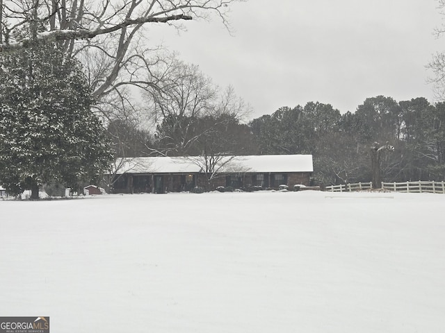 snowy yard featuring fence