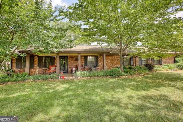 single story home with covered porch and a front yard