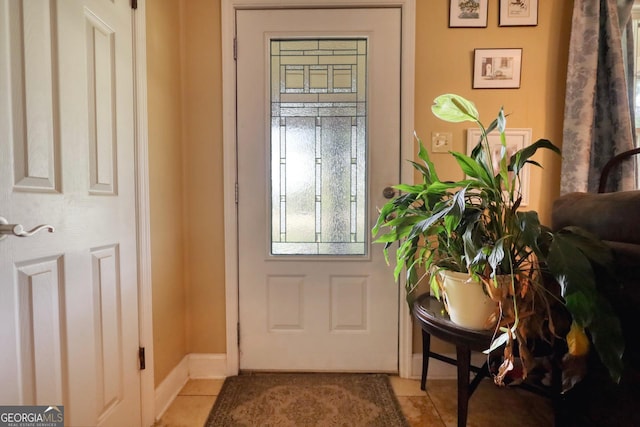 doorway to outside featuring light tile patterned floors and baseboards