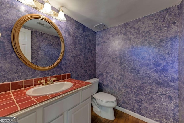 bathroom featuring hardwood / wood-style flooring, vanity, and toilet