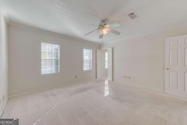 carpeted spare room featuring ceiling fan and ornamental molding