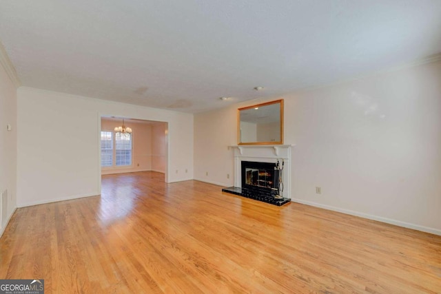 unfurnished living room with ornamental molding, a notable chandelier, and light hardwood / wood-style flooring