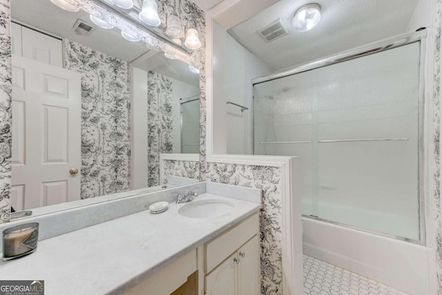 bathroom with vanity and combined bath / shower with glass door