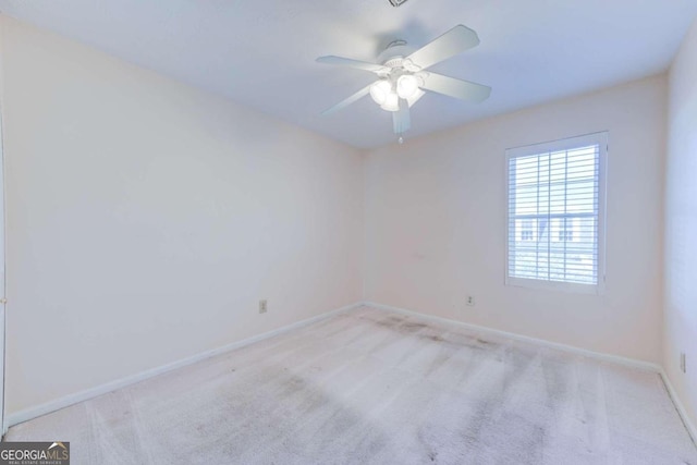 spare room featuring ceiling fan and light colored carpet