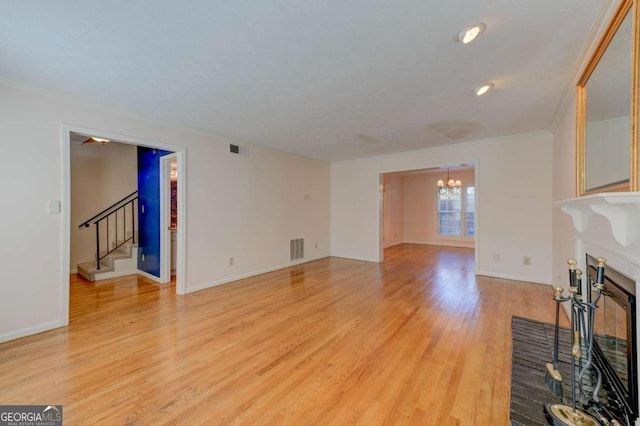 unfurnished living room with a chandelier, hardwood / wood-style floors, and a fireplace