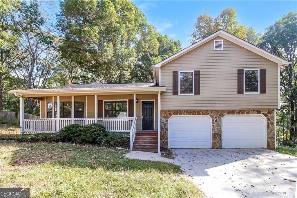 tri-level home featuring covered porch and a garage